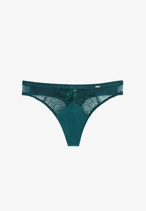 Teal lingerie tanga lavet af et blødt, glat stof med blonde accenter; har et prikket mønster og en detaljeret blomsterblonde foran.