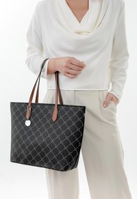 Zwarte tote bag met een diamanten patroon en zilveren accenten. Beschikt over leren handvatten in bruin. De tas heeft een gestructureerde vorm en een gladde textuur.