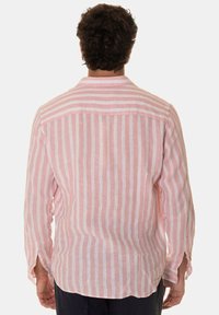 Camicia leggera in lino con righe verticali rosa e bianche, maniche lunghe e polsini con bottone, colletto classico e spacco sulla schiena.