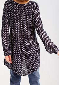 Marineblauwe blouse met lange mouwen en een bloemenpatroon, van lichtgewicht stof, met geplooide details bij de halslijn en een gebogen zoom.