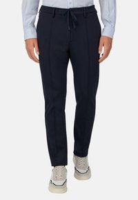 Morske hlače z vrvico v pasu, s slim fit krojem in dvema sprednjima žepoma. Narejene iz gladkega, mehkega materiala z diskretnim sijajem.