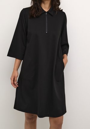 Black, short-sleeved dress with a collar and zip closure; features two side pockets and a relaxed fit; smooth texture.