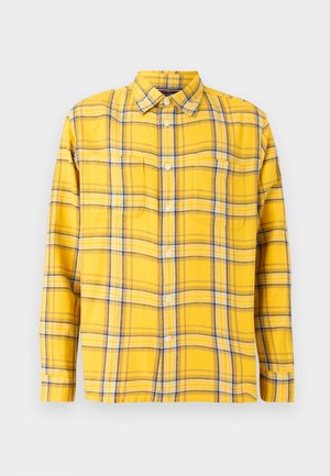 Camicia a quadri gialla con strisce blu e marroni, maniche lunghe, colletto button-down, due tasche sul petto e vestibilità rilassata. Materiale in cotone.