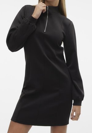 Schwarzes Kleid mit hohem Kragen, langen Puffärmeln und einem Reißverschluss vorne. Geschmeidiges Material mit figurbetonter Silhouette und Nahtdetails.