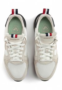 Lightweight sneakers with a white mesh body, beige suede accents, green insoles, and a striped red, white, and blue heel tab.