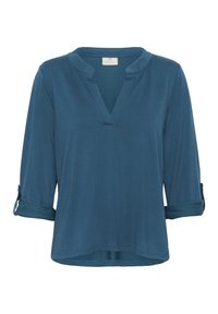 Chemise bleue à manches longues avec un col fendu et des manches retroussées maintenues par des pattes de boutonnage, présentée sur fond blanc.