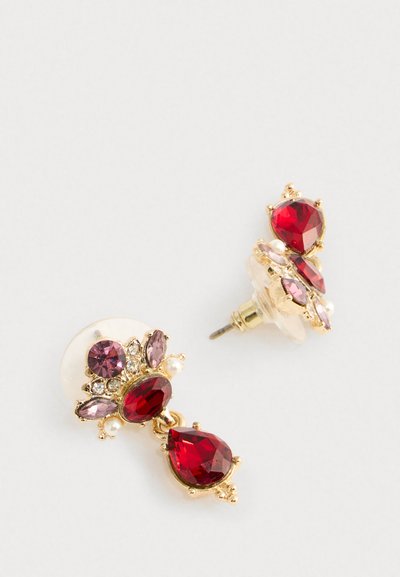 Gold-tone earrings with red teardrop and oval gemstones, pink accents, clear crystals, and small pearls on clear backing.
