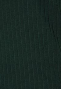 Mörkgrön ribbad stickad tyg med vertikala strukturerade ränder och ett mjukt, något stretchigt material.