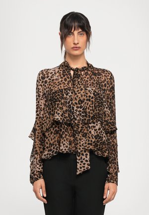 Blusa in stampa leopardo marrone e nera con orlo arricciato, collo a cravatta e maniche lunghe. Tessuto leggero con una texture trasparente. Pantaloni neri.
