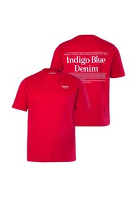 Červené bavlněné tričko s kulatým výstřihem, krátkými rukávy a bílým textem na přední i zadní straně, který uvádí "Indigo Blue Denim."