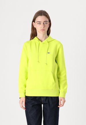 Felpa con cappuccio gialla neon, dotata di tasca frontale, stringhe regolabili e un piccolo logo sul petto sinistro. Tessuto morbido, vestibilità rilassata.