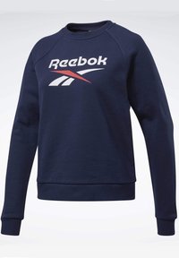Mörkblå sweatshirt med ribbad mudd och nederkant, med en vit och röd Reebok-logotyp på framsidan. Tillverkad av mjukt, strukturerat tyg.