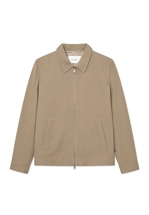 Tan jacket with a zip front, flat collar, two front pockets, and long sleeves. Smooth texture and minimal design. Brand label visible inside.