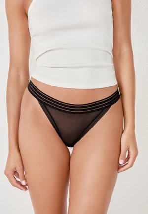Black sheer thong featuring triple strap detailing at the waistband and lace trim on the edges. Made of lightweight, soft material.