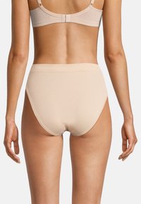 Mutande in cotone beige a vita alta con una texture liscia e un ampio elastico, viste da dietro, che rivelano un design senza cuciture.