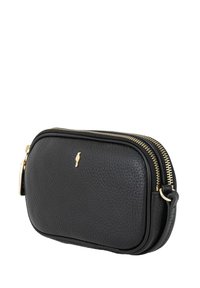 Czarna skórzana torba na ramię o chropowatej teksturze, ze złotym zamkiem błyskawicznym i wytłoczonym logo, z odpinanym paskiem i zaokrąglonym kształtem.