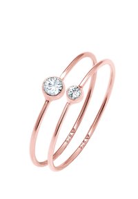 Anello doppio in oro rosa con due pietre trasparenti, una grande e una più piccola, incastonate in impostazioni minimaliste a becco, design della fascia liscia.