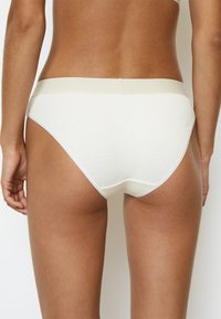 Slip bikini bianchi in cotone con vita elastica morbida e una superficie liscia. Presenta cuciture minime e un design a taglio classico.