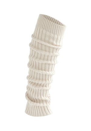 Jambières en tricot côtelé couleur crème avec une texture tombante, conçues pour la chaleur et le style.
