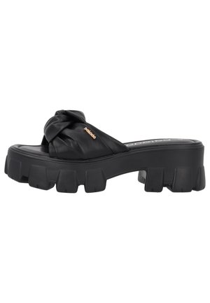 Sort platform sandal med tykket, rillesåle og overdel i knyttet læder med lille guld logo fra mærket.