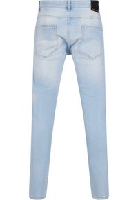 Vaaleansiniset farkut, joissa on kestävä slim fit -malli, viidellä taskulla ja erottuvat sauman ompeleet. Takana on kaksi läppätaskua.
