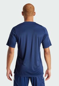 Marineblauw sportshirt gemaakt van gladde, lichte stof; korte mouwen, ronde hals en subtiele naaddetails op de achterkant.