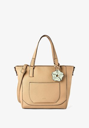 Tan leather handbag with front pocket, two handles, adjustable shoulder strap, and a decorative white flower charm attached.