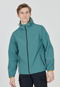 Teal mjukskaljacka med dragkedja fram, justerbar huva och orange detaljer. Har elastiska ärmslut och dragkedjefickor på sidorna.