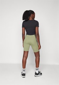 adidas Sportswear FUTURE ICONS THREE STRIPES BIKER SHORT - Leggings - tent green