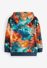 Sweat-shirt à capuche avec un motif abstrait coloré dans des tons d'orange, de bleu et de teal. Présente un ourlet et des poignets en bleu marine uni. Tissu doux et texturé.