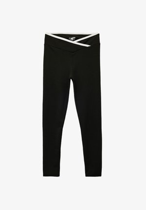 Leggings noirs avec une large taille croisée accentuée de blanc. Fabriqués en tissu lisse et extensible. Design à pleine longueur.