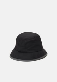 Cappello a secchiello nero realizzato in tessuto leggero, con una corona rotonda e un'ampia visiera flessibile caratterizzata da cuciture testurizzate lungo i bordi.