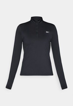 Maglietta atletica nera a maniche lunghe con colletto alto e zip frontale a metà. Presenta un piccolo logo bianco sul petto. Tessuto liscio e elastico.