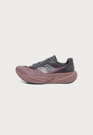 Vue latérale d'une chaussure de course grise et mauve avec une semelle épaisse et un grand logo argenté "N" sur le côté.