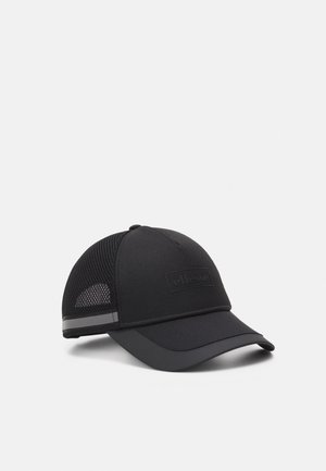 Casquette de baseball noire avec panneaux arrière en mesh, bande réfléchissante au-dessus de la visière et logo "ellesse" embossé sur le panneau avant.