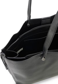 Zwarte leren tote bag met een textuur oppervlak, ritssluiting en twee handvatten. Beschikt over meerdere vakken en een zachte binnenvoering.