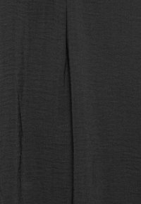 Svart, strukturerad tyg med ett subtilt vävmönster, som har en lätt drapering. Materialet är lättviktigt och har en slät yta.