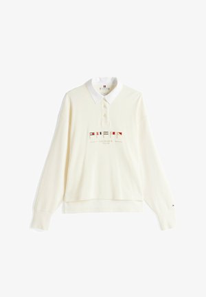 Polo à manches longues couleur crème avec col blanc, patte de boutonnage, petites broderies de drapeaux colorés et texte "Hilfiger Since 1985" sur le devant.