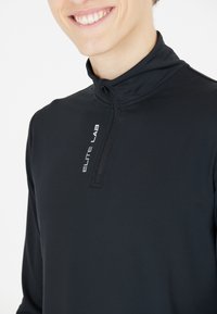 Sort langærmet træningsshirt med lynlåskrave. Har "ELITE LAB" logo i hvidt på forsiden. Glat, strækbart stof.
