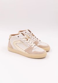 Höga sneakers i vit och beige mocka med guldaccenter. Har en texturerad gummisula och kontrasterande snörning. Diskret logotypdetalj.
