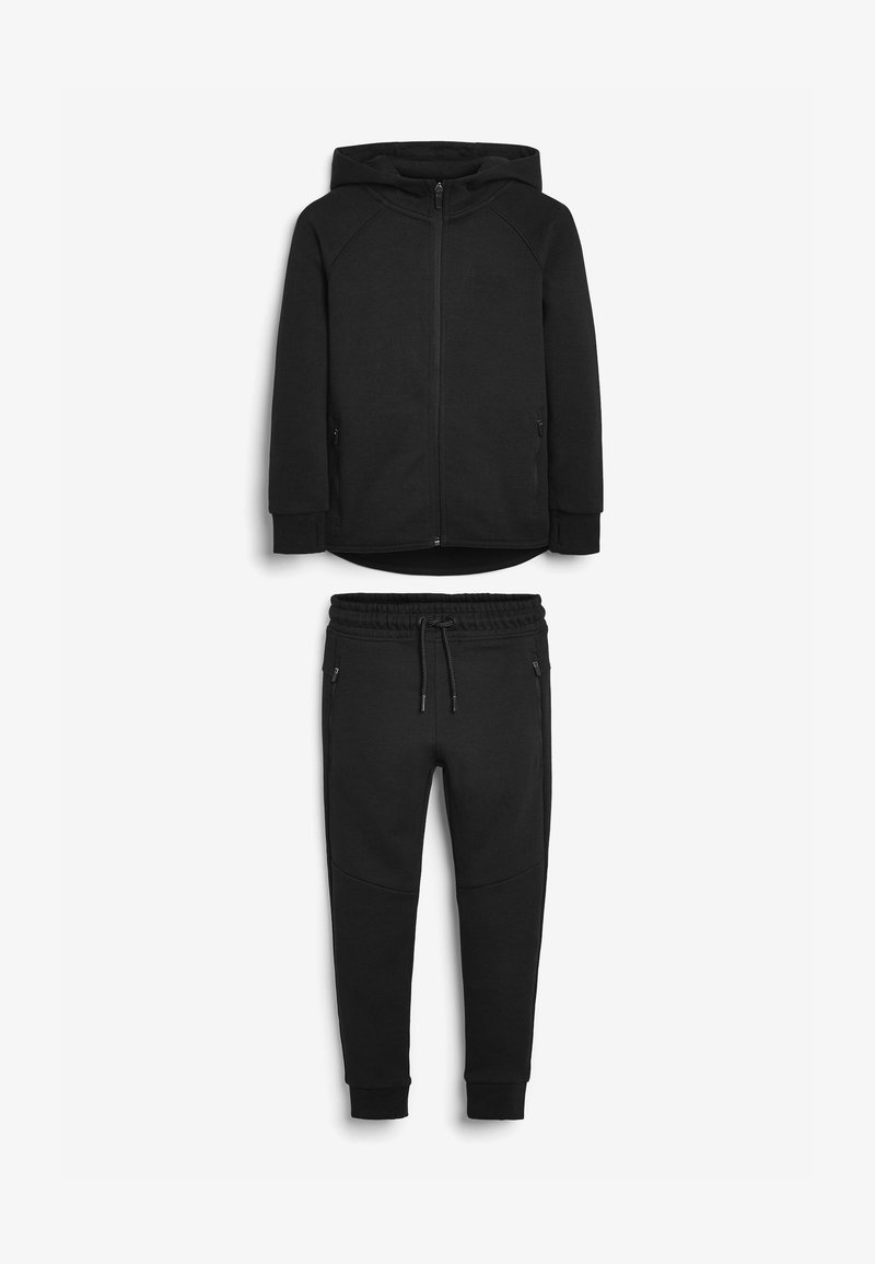 Sort hættejakke med lynlås og sidelommer, parret med matchende sorte joggers med elastisk talje og tapered ankel.