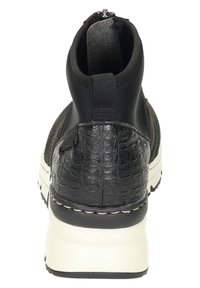 Botines negros con textura de reptil, laterales elásticos y suela gruesa blanca. Detalle de cremallera en la parte trasera para facilitar su uso.