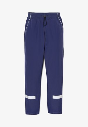 Granatowe spodnie sportowe z elastycznym pasem i sznurkiem, zamykanymi na zamek kieszeniami oraz białymi odblaskowymi paskami przy kostkach.