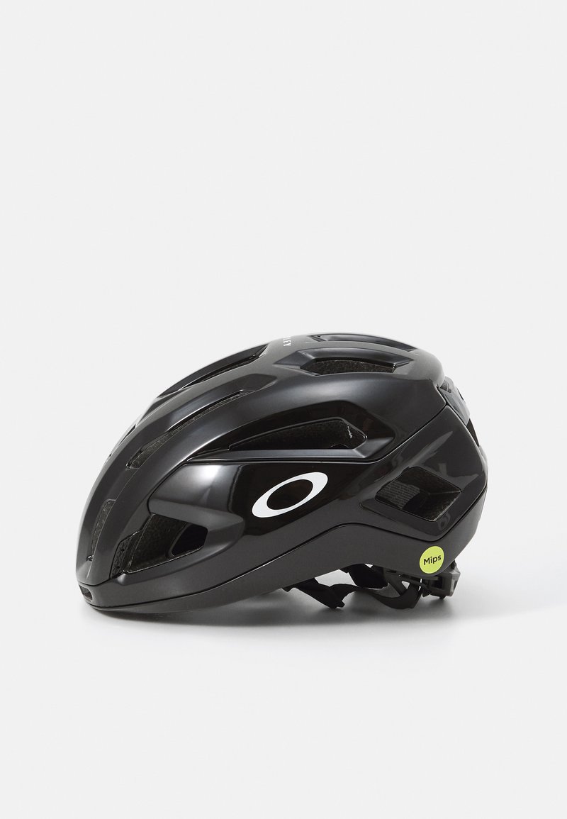 Black cycling helmet with aerodynamic design, multiple ventilation slots, MIPS label in green, and a prominent white logo on the side.