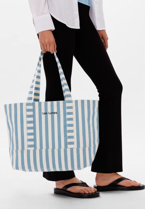 Borsa a spalla in tela a righe blu e bianca con due manici. Presenta un logo stampato "Les Lunes" sul davanti, un design spazioso e un materiale resistente.