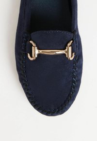 Mocassini in suede blu navy con un accento in hardware dorato, cuciture dettagliate e una finitura liscia e strutturata.