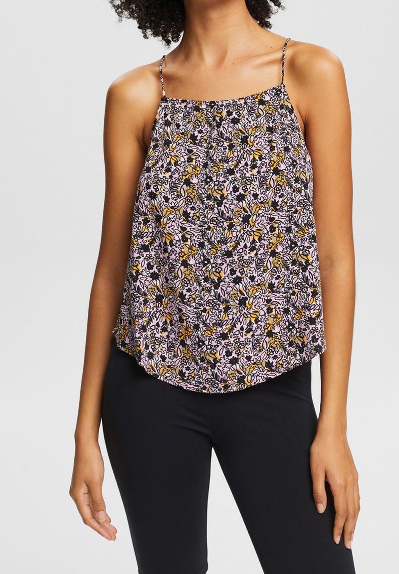 Top de tirantes finos con estampado floral, con una base rosa y un patrón floral en negro, amarillo y blanco; corte holgado y dobladillo redondeado.