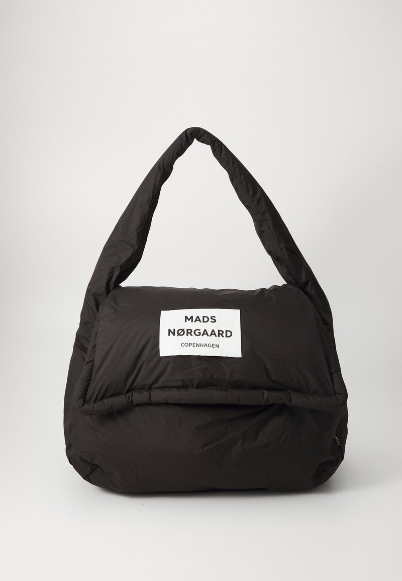 Borsa nera imbottita con un'etichetta bianca ben visibile che riporta "MADS NØRGAARD COPENHAGEN." Manico curvo distintivo e texture morbida.