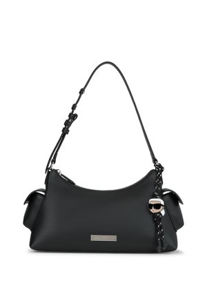 Mustat nahkaiset käsilaukku, jossa on lyhyt säädettävä olkahihna, sivutaskut, hopeinen logo-plaketti ja hahmotavallinen avaimenperä, jossa on aurinkolasit ja valkoinen tukka.