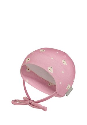 Soft pink baby bonnet with teddy bear and polka dot pattern, featuring tied straps and a small fabric brand tag on the side.